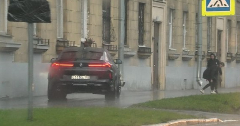На фото видно, как BMW главы района разгоняет пешеходов на тротуаре
